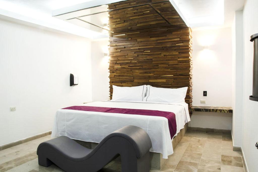 a bedroom with a large bed with a brick wall at Motel Moon in Puebla