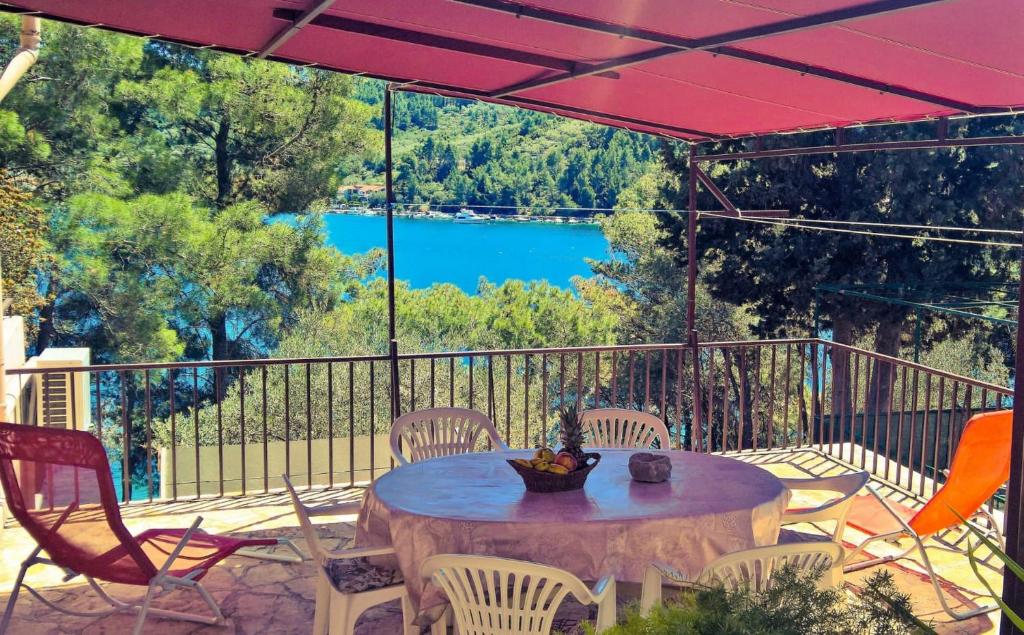 uma mesa e cadeiras numa varanda com vista para um lago em Seafront Apartment Dana em Vela Luka