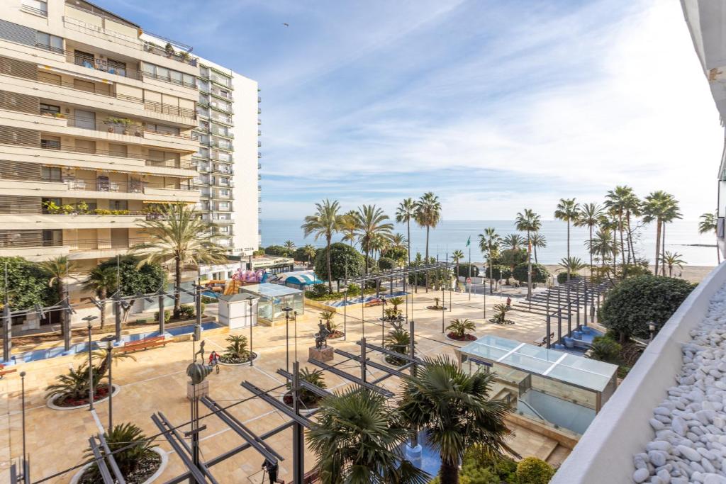 a view of a park with palm trees and a building at Apartamento Marbella Centro Av. del Mar in Marbella