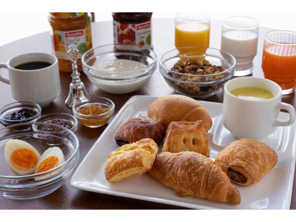 a plate of pastries on a table with cups of coffee at R&B Hotel Sendai Higashiguchi - Vacation STAY 14656v in Sendai