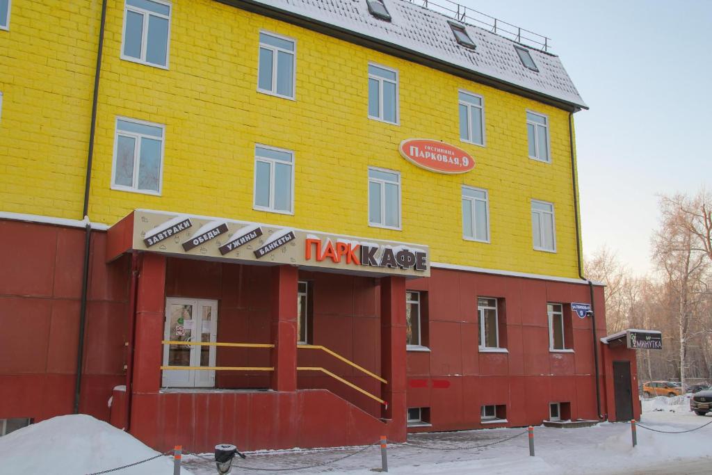 un edificio amarillo y rojo con un letrero. en Parkovaya 9, en Severodvinsk