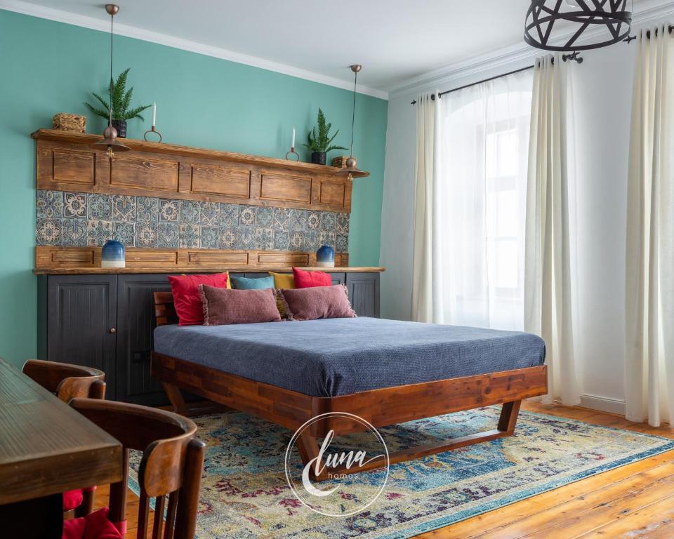 1 dormitorio con 1 cama con pared azul en Luna Homes en Sibiu