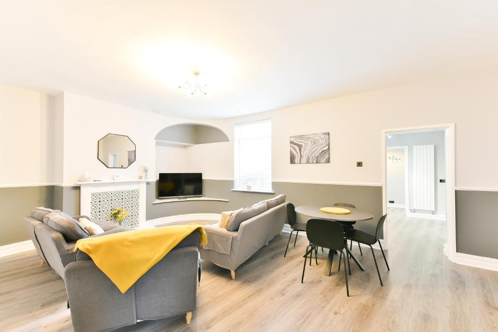 un soggiorno con un divano e un tavolo di 4 Bedroom, 2 bathroom house - Free Parking a Pontefract