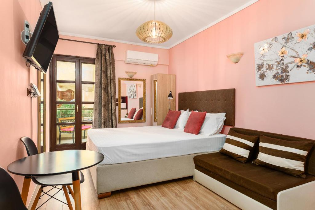 a bedroom with a bed and a couch and a tv at Manina Superior Apartment in Thessaloniki