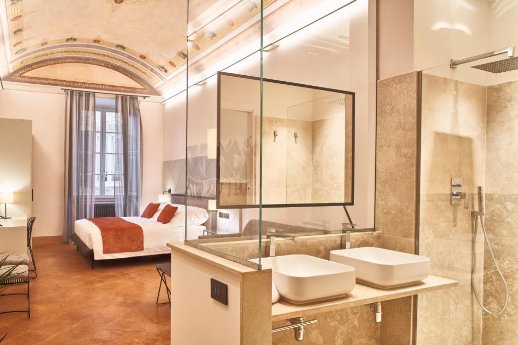 a bathroom with two sinks and a bed at Residenza d'epoca San Martino 29 in Siena