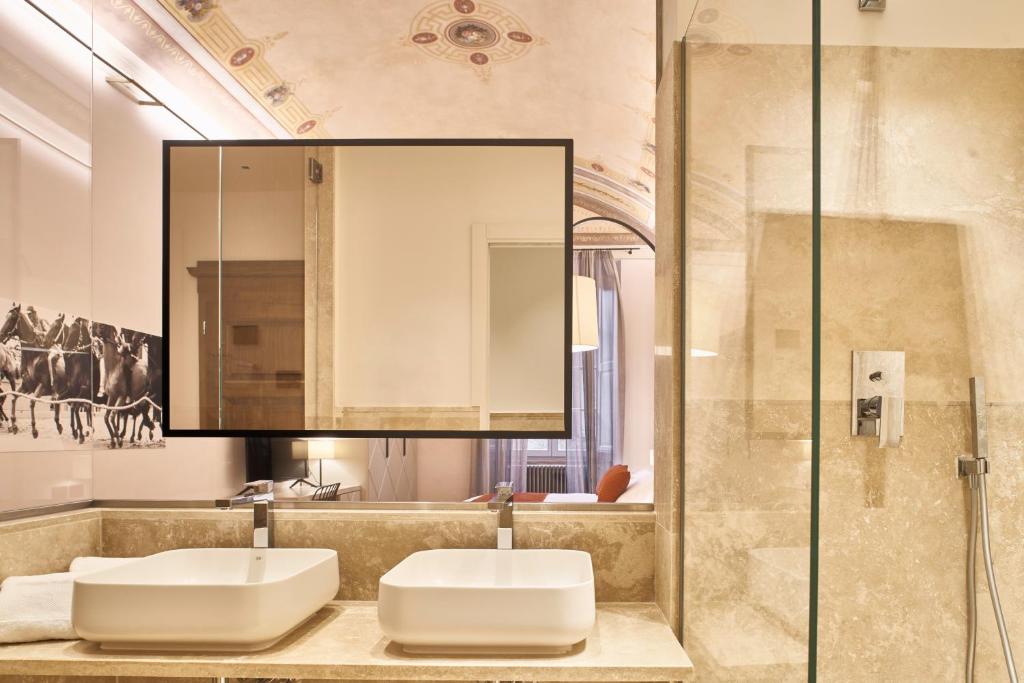 a bathroom with two sinks and a mirror at Residenza d'epoca San Martino 29 in Siena