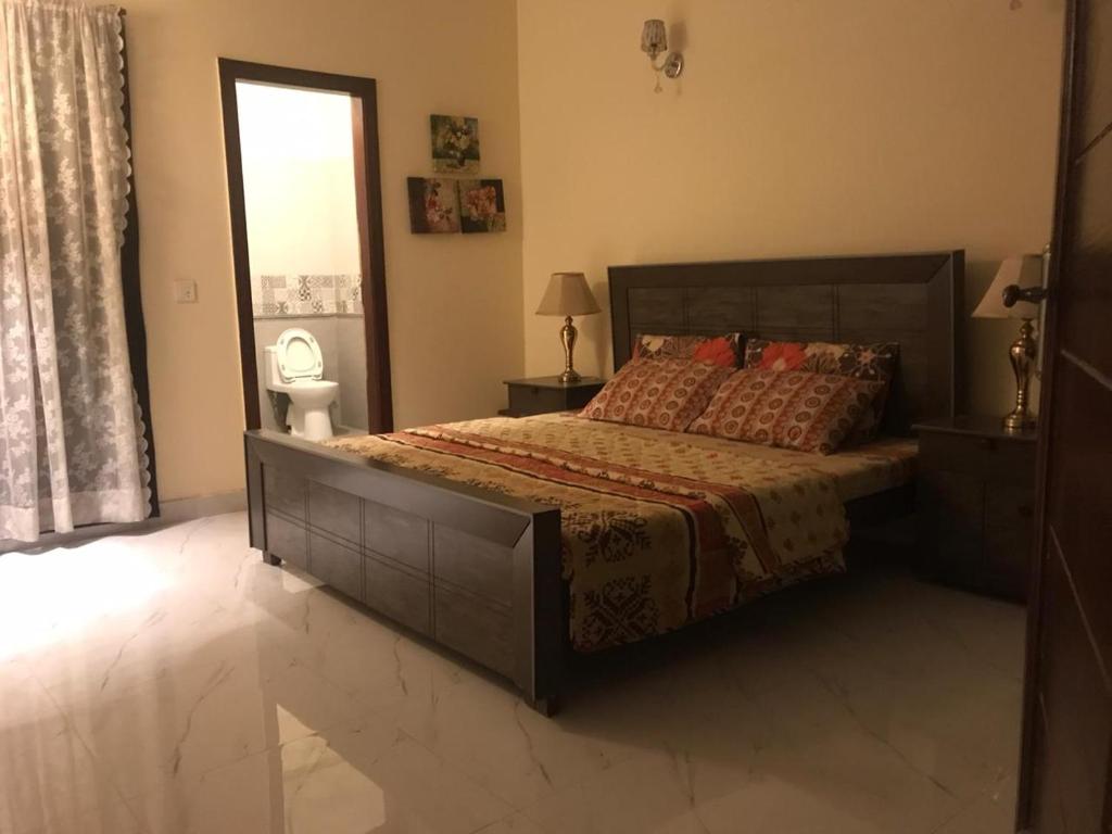 a bedroom with a large bed and a window at King's Paradise in Lahore
