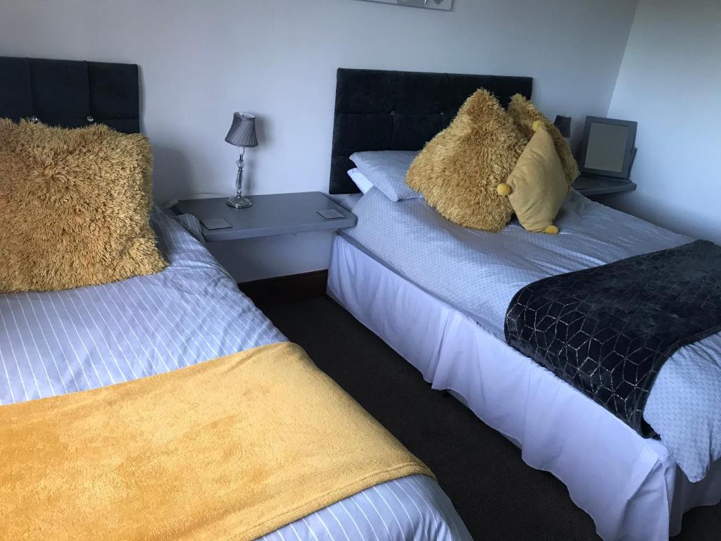 a bedroom with two beds with stuffed animals on them at The Coach and Horses in Parkham