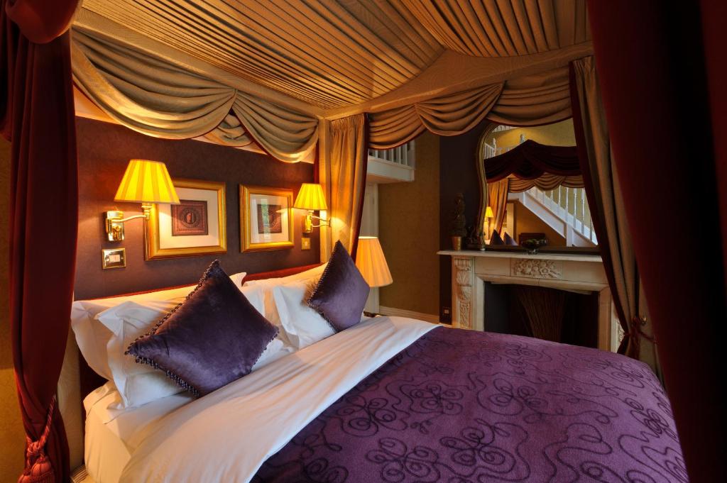 a bedroom with a large bed with purple and white pillows at The Colonnade in London