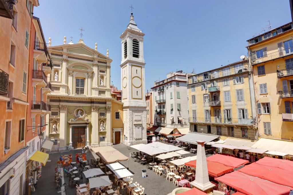une rue de la ville avec une tour d'horloge au milieu dans l'établissement FONTAINE - CHARMING PROVENCAL, Clim, 6 GUEST, OLD TOWN NICE, à Nice