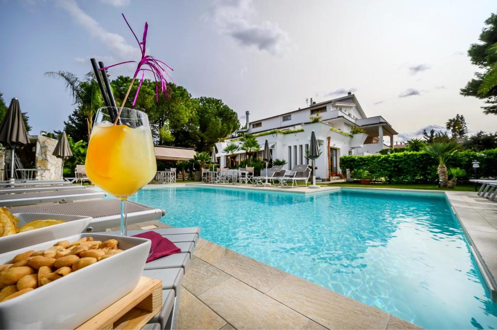 ein Getränk auf einem Tisch neben einem Pool in der Unterkunft Villa San Lorenzo in Palermo