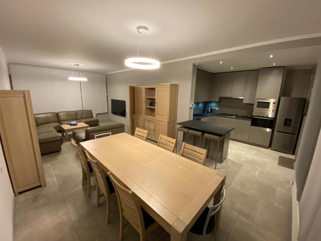 een keuken en een woonkamer met een houten tafel en stoelen bij Villa D&G in Oostende