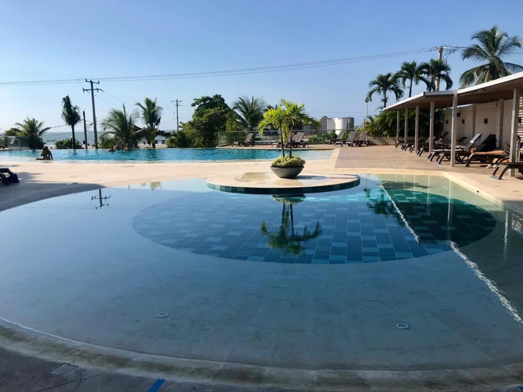 a swimming pool in a resort with a fountain at Lujoso Apartamento Sector Morros Vista al Mar in Cartagena de Indias