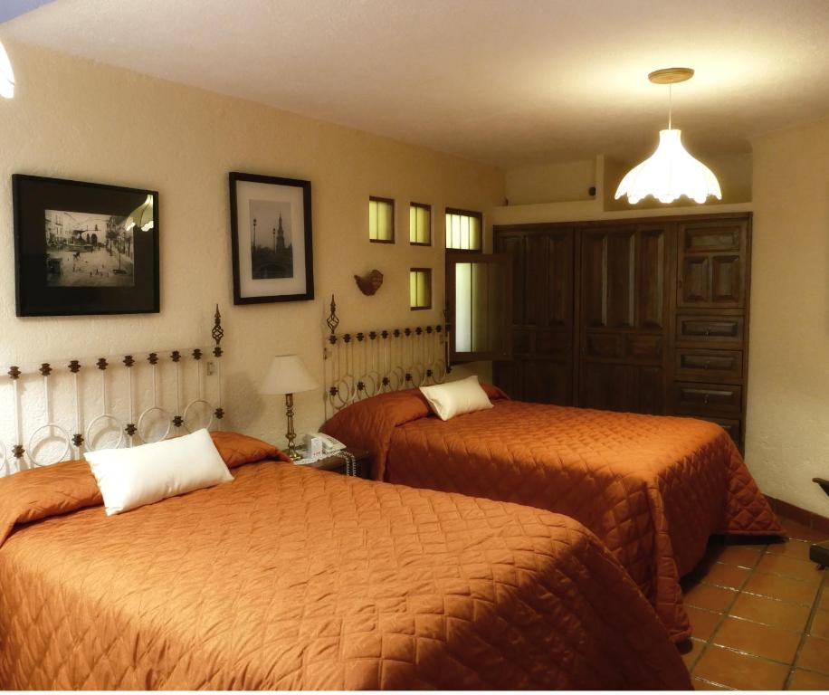 a hotel room with two beds in a room at El Meson de los Poetas in Guanajuato