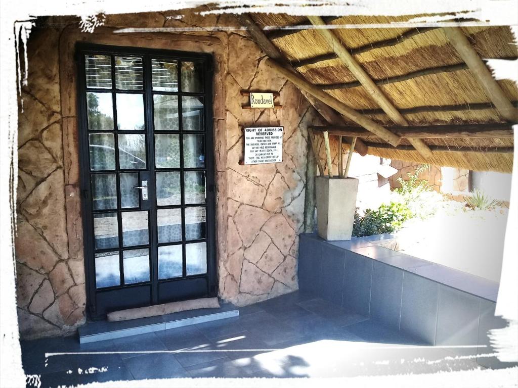 a stone building with a door and windows at Matlapeng Country Estate in Vanderbijlpark
