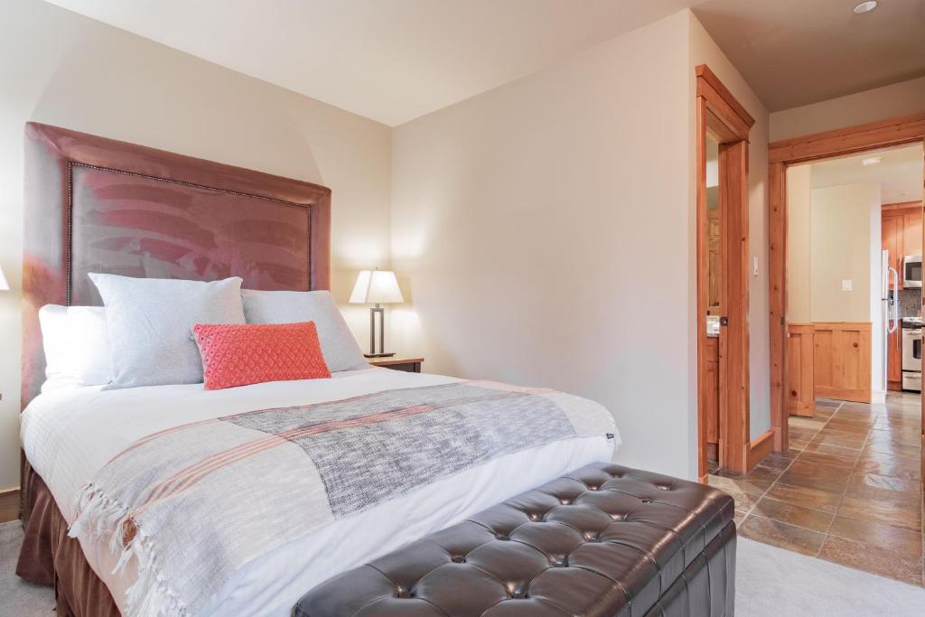 a bedroom with a large bed with a red pillow at Wildwood Lodge by Outpost Whistler in Whistler