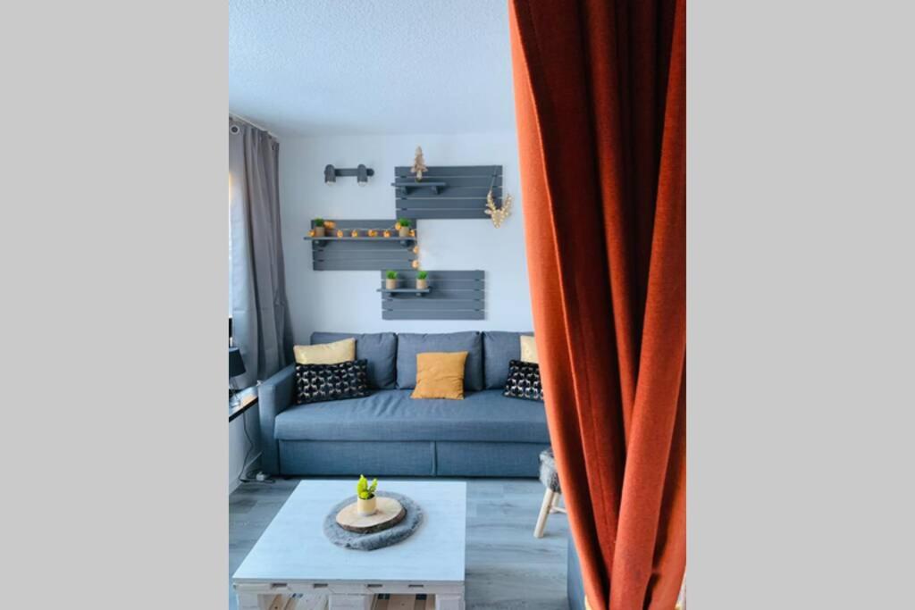 a living room with a blue couch and a table at Studio 1600 Pied des pistes avec magnifique vue in Puy-Saint-Vincent