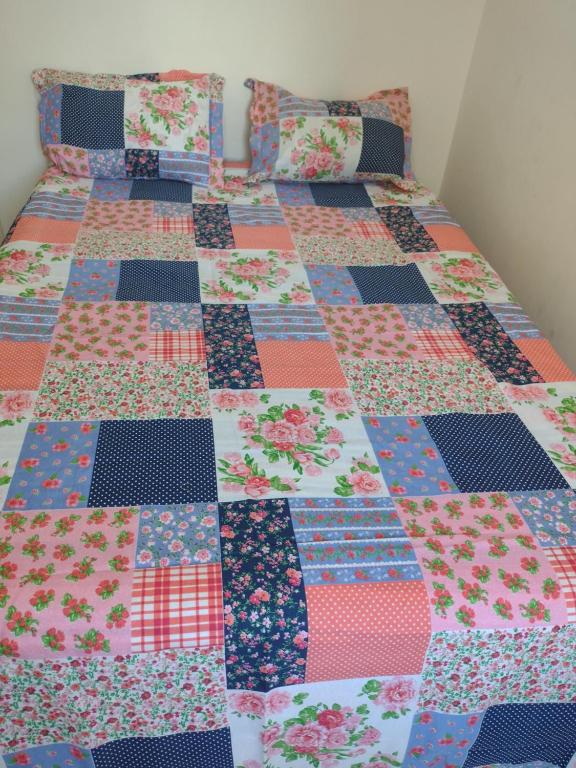 a quilt on a bed in a room at mar e sol in Praia Grande