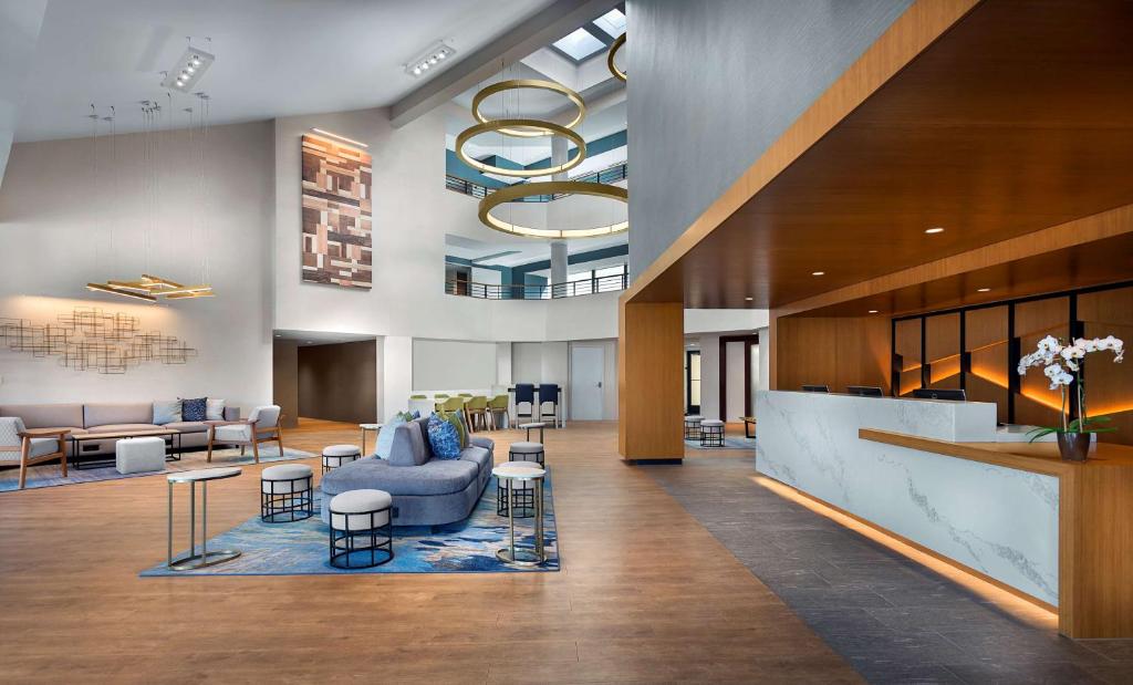 a lobby with a couch and chairs and tables at Sonesta Silicon Valley in Milpitas
