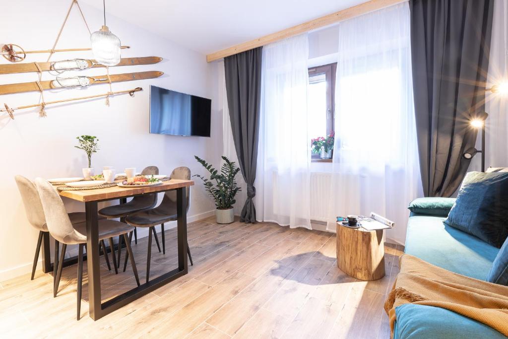 a living room with a dining room table and a couch at Apartament "Nosal" Droga na bystre Zakopane in Zakopane