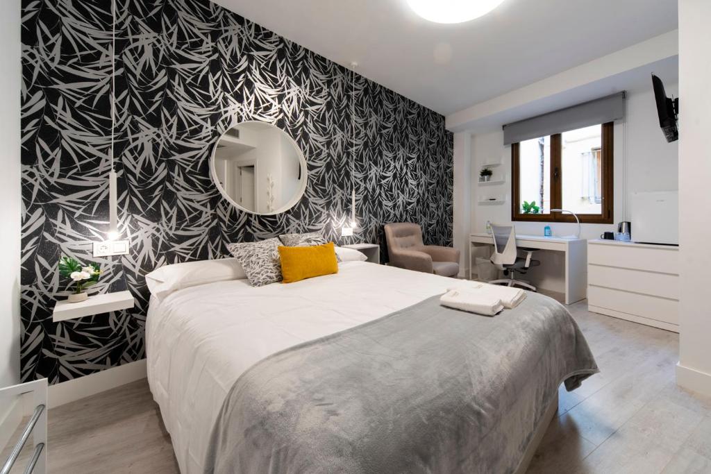 a bedroom with a large bed and a black and white wall at Vizcainos Home Away in Segovia