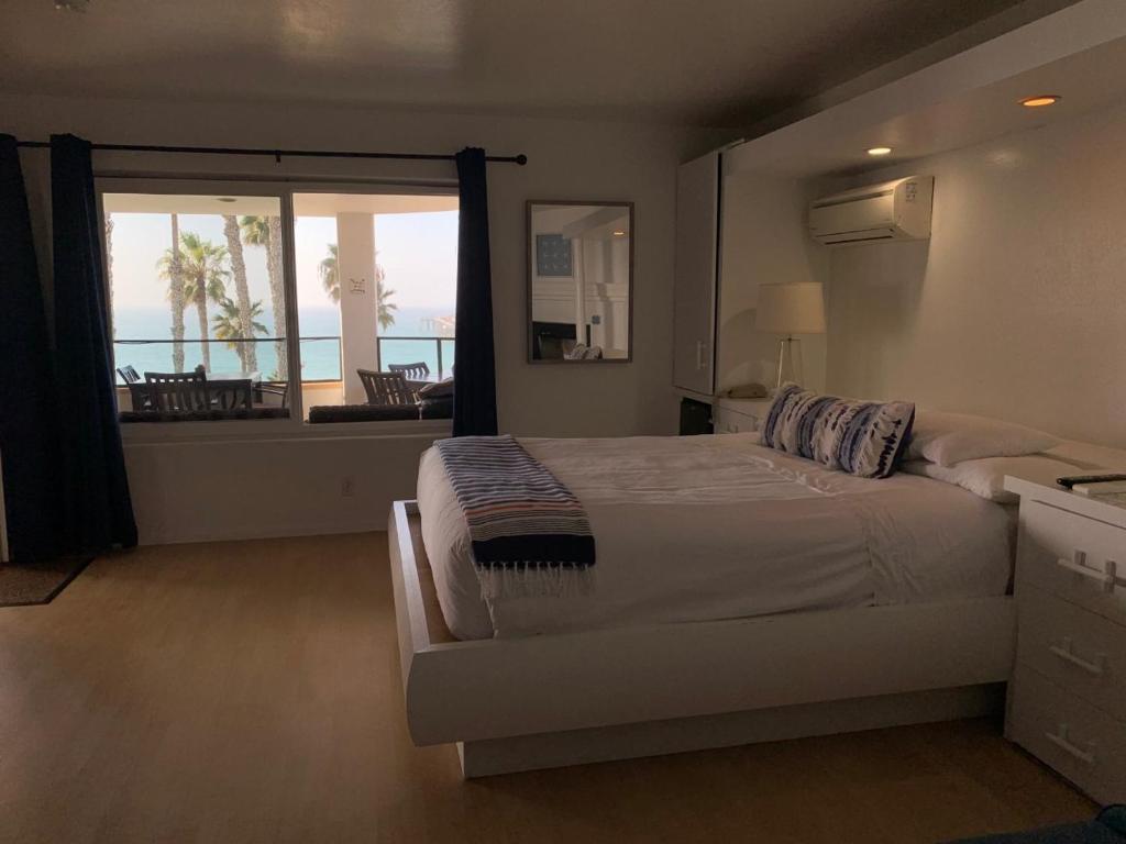 a bedroom with a bed and a view of the ocean at Casa Tropicana in San Clemente