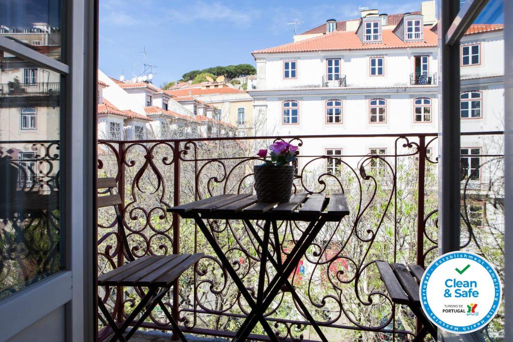 a table on a balcony with a view of a building at Alfama Sophisticate Flat With Balconies 2Bedrs 2Baths & AC in 19th Century Building Historic Center in Lisbon