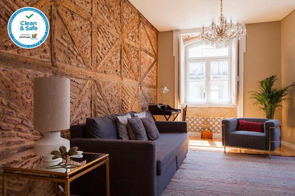 una sala de estar con sofá y una gran pared de madera. en Alfama Baixa Spacious And Bright Apartment Blends the Historic and the Contemporary 2 Bedrs & 2 Bathrs AC 18th Century Building, en Lisboa