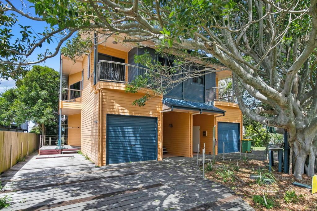 a house with two garage doors and a tree at Fig Tree Down in Point Lookout