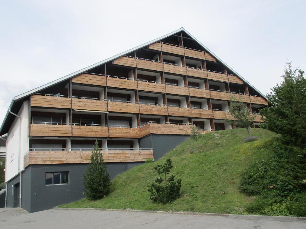 un edificio con una collina erbosa di fronte ad esso di La Prada - 2 Zimmerwohnung mit 40m2 für max. 3 Personen a Laax