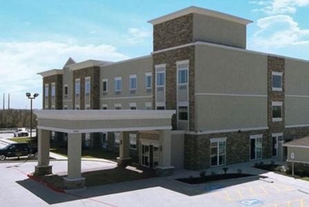 een groot gebouw met een parkeerplaats ervoor bij Garner Hotel Victoria - East by IHG in Victoria