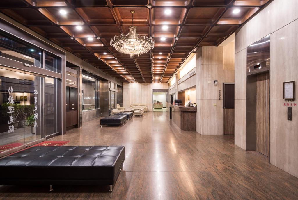 a lobby with a black leather couch in a building at Twinstar Hotel in Taichung