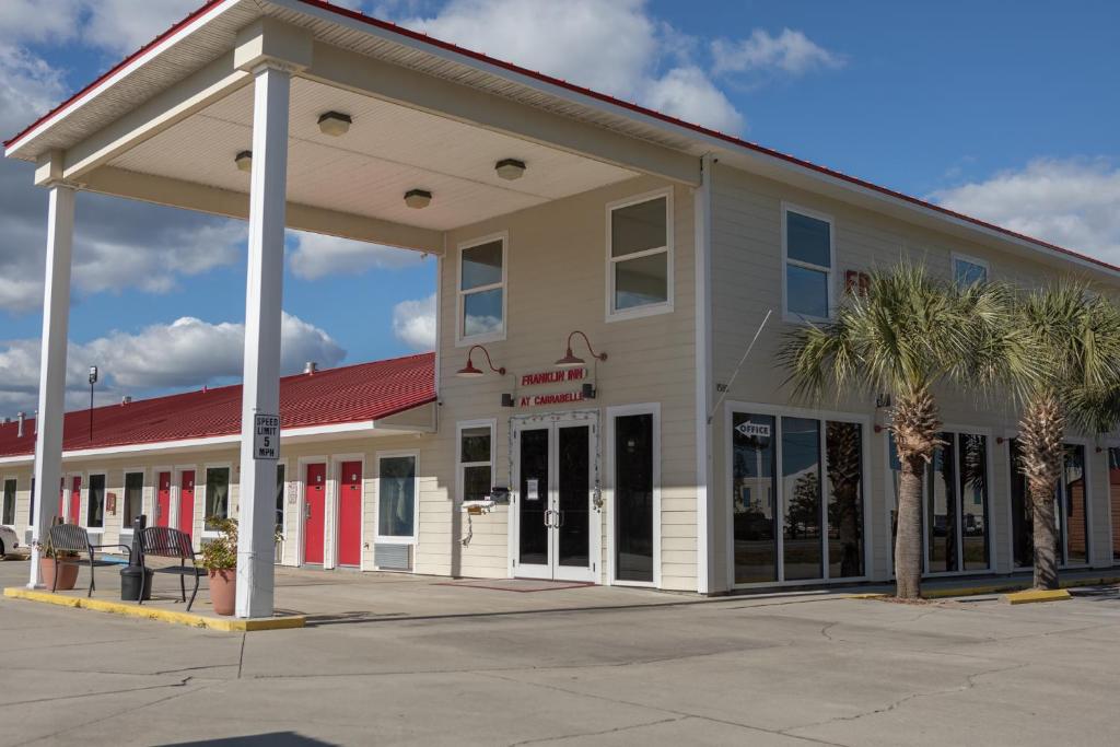 een groot gebouw met palmbomen ervoor bij franklin inn in Carrabelle