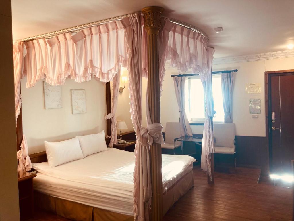 仁愛鄉的住宿－維多利亞山莊，一间卧室设有天蓬床和窗户。