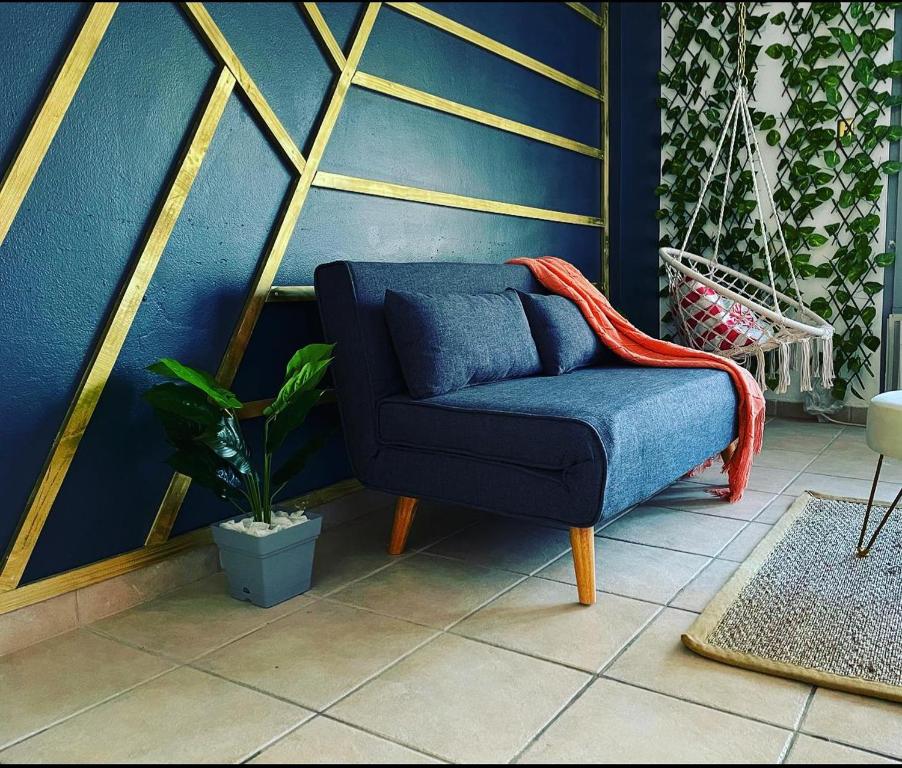 Cond. St. Tropez في سان خوان: أريكة زرقاء في غرفة ذات جدار أزرق