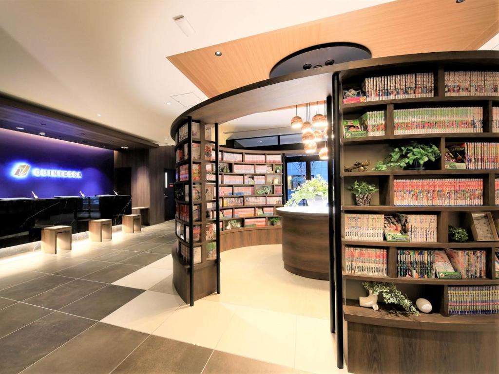 a library with shelves of books and a piano at QuintessaHotel FukuokaTenjin Comic&Books in Fukuoka
