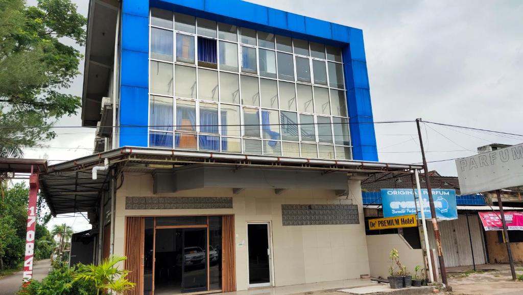 a blue and white building with a balcony at De' Premium Hotel Musi Raya in Sukarami