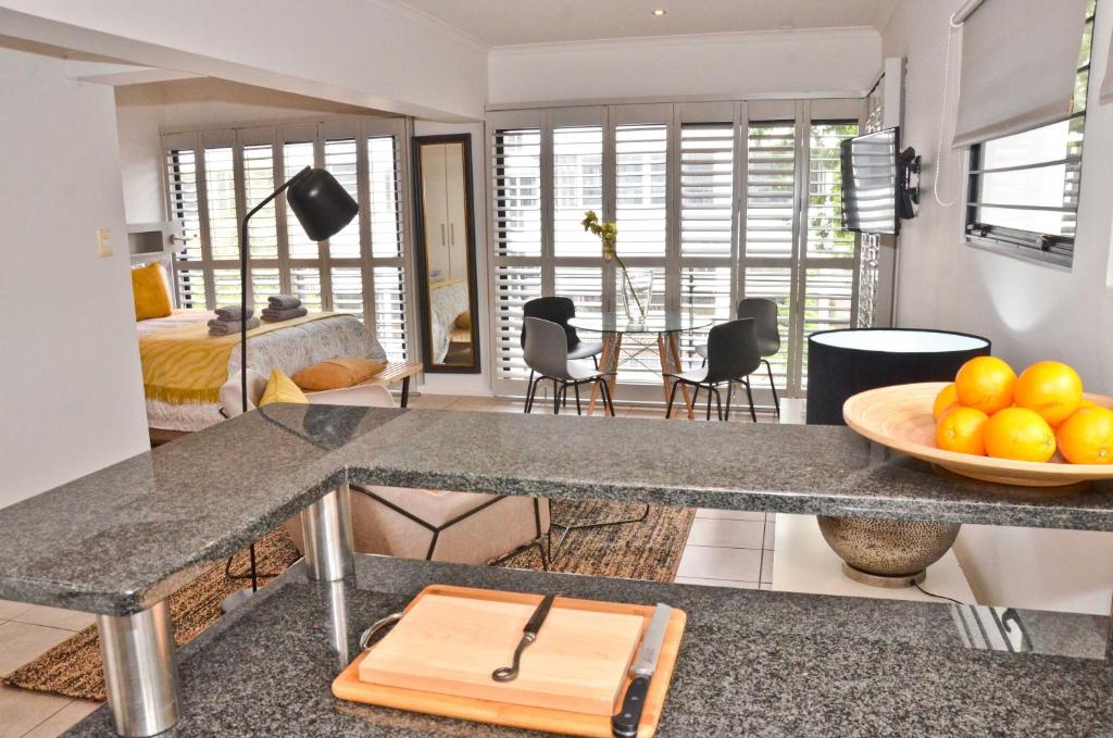 a kitchen and living room with a bowl of oranges on a counter at Concord Modern Apartment in Stellenbosch in Stellenbosch