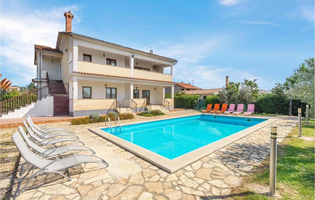 a villa with a swimming pool in front of a house at Beautiful Home In Visnjan With Wifi in Višnjan