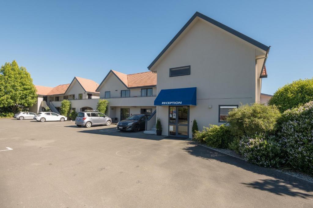 ein Gebäude mit Autos auf einem Parkplatz in der Unterkunft Bella Vista Motel Nelson in Nelson