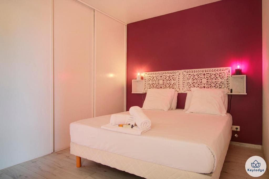 Un dormitorio con una cama blanca con paredes moradas en T2 - Evid8nce - 42m2 - Piscine - Centre de Saint-Denis, en Saint-Denis