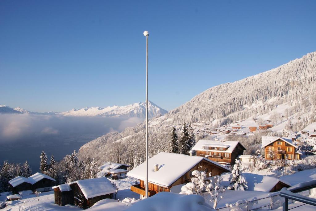 a ski lodge in the mountains covered in snow at Hotel Fassbind Beausite in Beatenberg