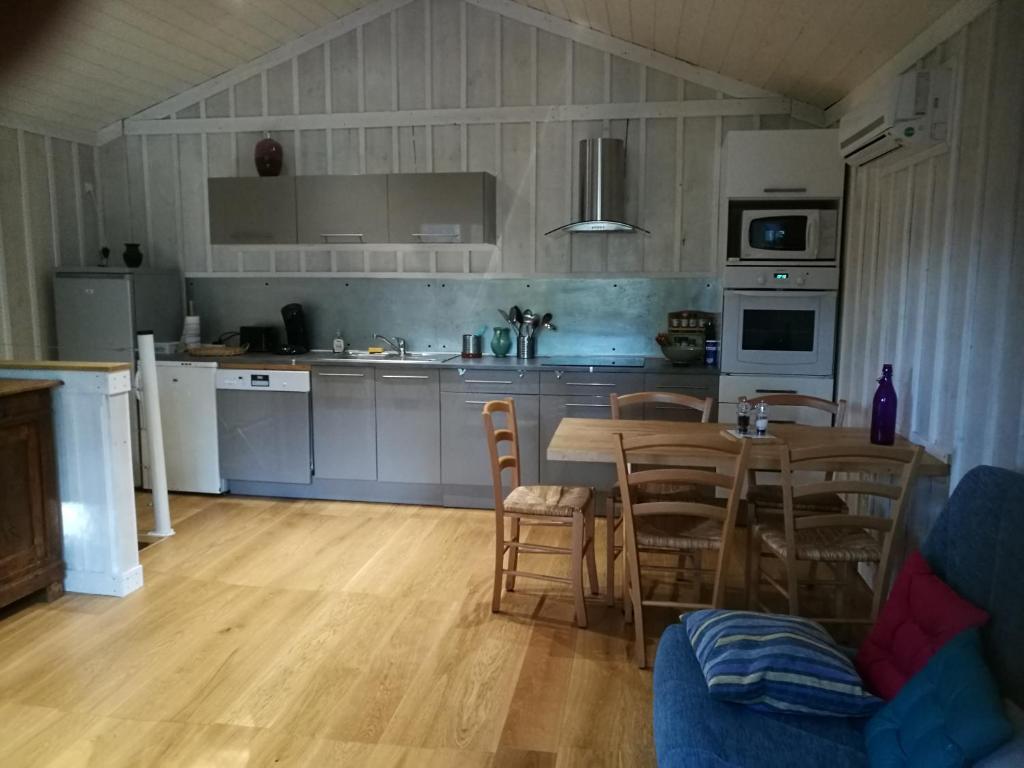 a kitchen with a table and chairs in a room at La cabane du Truquet in Lège-Cap-Ferret