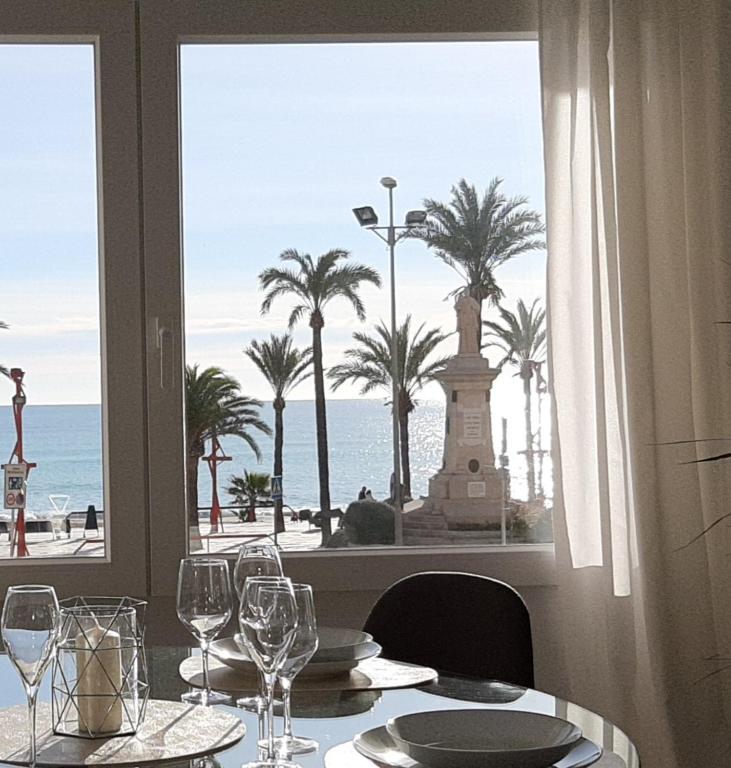 a table with wine glasses and a view of the ocean at Cor de Vinaròs in Vinarós