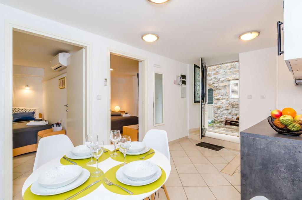a dining room and living room with a table and chairs at Apartment Domix in Dubrovnik