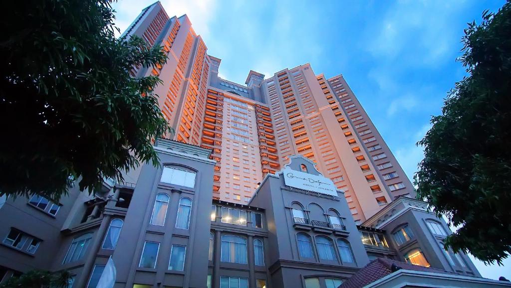 a tall building with many windows in a city at Grand Dafam Ancol Jakarta in Jakarta