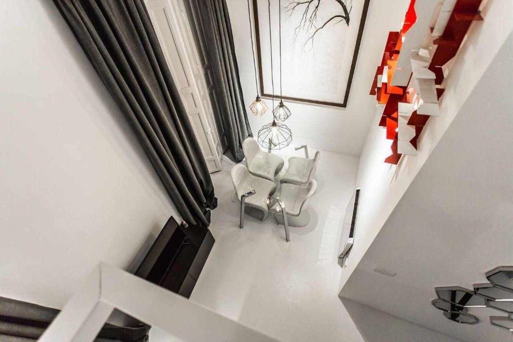 salon z 2 krzesłami i schodami w obiekcie Carmen Modern & luxury space near Plaza Mayor w Madrycie
