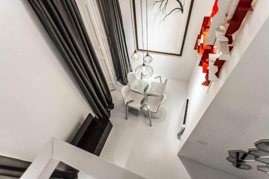 マドリードにあるCarmen Modern y luxury space near Plaza Mayorのリビングルーム(椅子2脚、階段付)