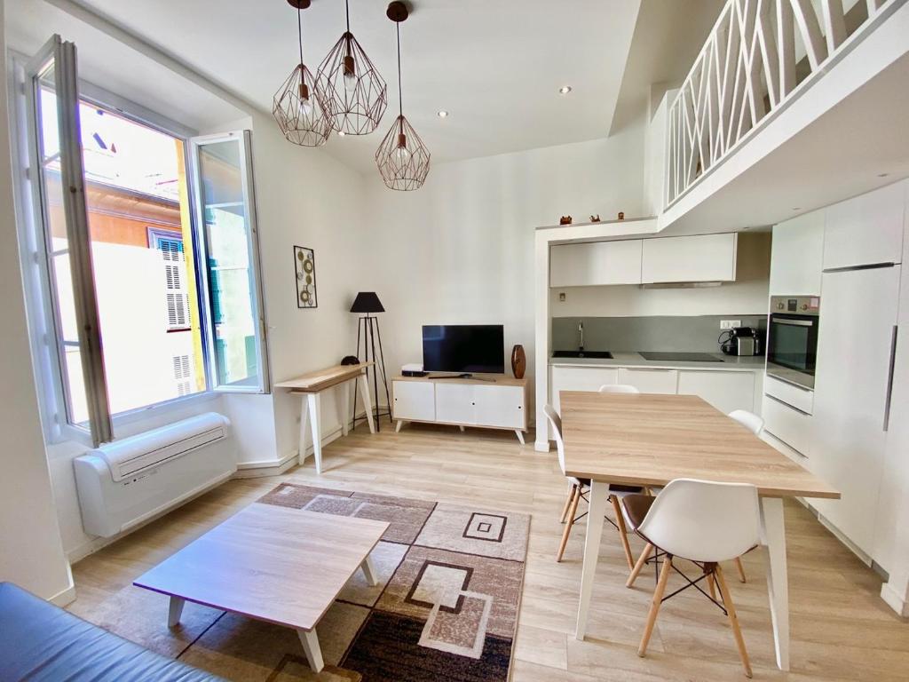 Il comprend un salon avec une table en bois et une cuisine. dans l'établissement Studio La Pietonne, à Menton