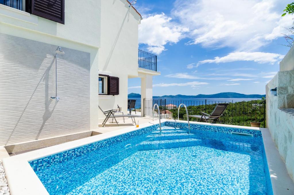 a swimming pool in a villa with a view of the ocean at Villa Sofija Dubrovnik & Peljesac Region in Slano